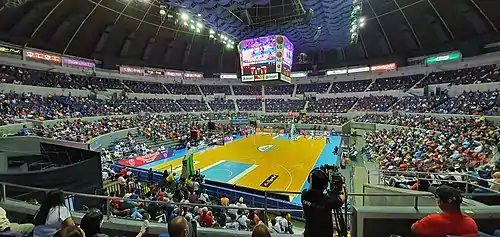 The view of the Coliseum from the Lower Box level, during the 2021 PBA season between the Barangay Ginebra San Miguel and the Magnolia Hotshots. The rivalry between the teams is often known as the Manila Clasico