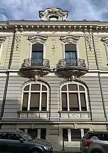 Complex wrought iron papo-de-rola balconies with elaborate Rococo Revival shells and round shapes (aka volutes) under them, on the facade of Strada General H. M. Berthelot no. 41, Bucharest, unknown architect, 1911