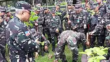 A member of the Quezon City TAS Unit demonstrates the actual planting of a sapling while BGen Johnny Macanas AFP - AFP Deputy J-9 looks on.