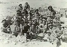 Australian soldiers sitting amongst desert rubble