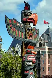 A multi-coloured pole with three faces and two sets of wings.