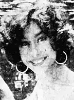 A 22-year-old woman with dark hair smiling at the camera.