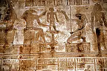 The god Khnum, accompanied by Heqet, moulds Ihy in a relief from the mammisi (birth temple) at Dendera Temple complex