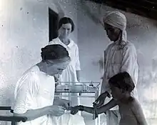 Photograph of Kerr vaccinating a child