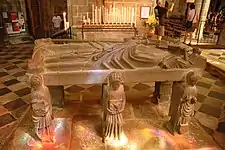 The flagstone depicting Saint Ronan viewed from the other side. The second reclining angel by Ronan's head is touching the top of the cross.