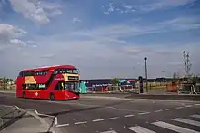 A route EL1 bus on the new Northgate Road extension passing the newly opened Barking Riverside pier in summer 2022.