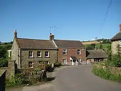 Two storey stone houses with a road in front.