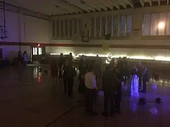 This photo is one of the only known representations of the dance itself and highlights the multiple issues the school faced at the Harvey Street Location, including limited space, inability to customize the space with school colors and branding, and a lackluster event space which was often commandeered by the diocese.