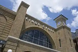 A railway station with a brick façade and a clock on one side