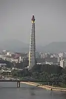 Very tall plinth with a statue of a flame in a cauldron on top