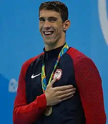 Michael Phelps with a gold medal hung around his neck on a red ribbon