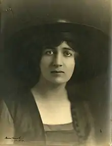 A young white woman with dark eyes, wearing a hat with a wide brim. Her expression might be described as anxious or sad.
