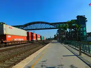 Norwalk/Santa Fe Springs station in 2016, with a BNSF freight train on the left track