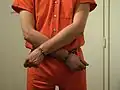 Inmate in belly chain with the arms crossed (high security restraint)