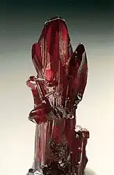 Proustite (long prismatic crystal) – Chañarcillo, Copiapo Province,  Chile. Specimen height is 4 cm.