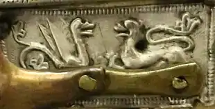 A griffin and lion face each other in hostility, indicated by their raised hindlegs. The figures are placed above Jesus' left arm.