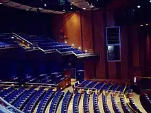 Theater with blue seats and wood paneled walls