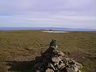 Cairn on the north top of Stybarrow Dodd incorporating the slate marker. Beyond is the intermittent pool, and the remains of the wall