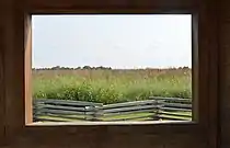 The central attraction of the Battle of Island Mound State Historic Site is its viewing station, which contains several informational signs and offers this framed view of the site and a split rail fence.