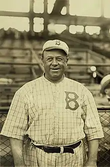 A large, smiling man in old-style baseball uniform