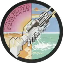 The circle sticker at the right-centre position shows two machines clasped together, resembling a handshake. The whole circle is divided into four quarters in different colours. The pink quarter, located on upper-left, has the sun shining and "PINK FLOYD" in big font; below the band name is "WISH YOU WERE HERE" in small font. The yellow quarter at lower-left displays sand dunes. The blue quarter at upper-right shows blue skies. The green quarter at lower-right displays green- or teal-coloured water.