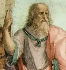 an ancient Greek philosopher traditionally identified as Plato points skywards, employing the 'declarative finger' gesture